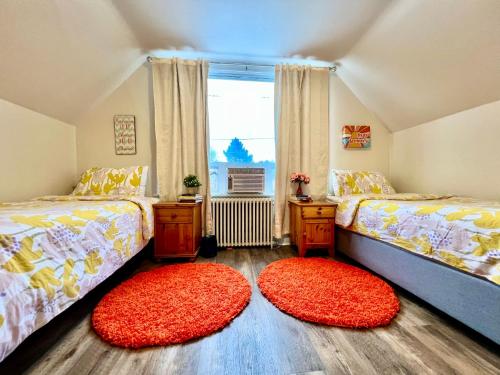 una camera con due letti e due tappeti rossi di Private Room with 2 Twin Beds- Air Conditioning and Shared Bathrooms a Seattle