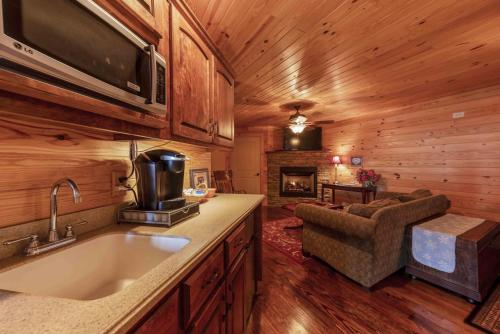 a kitchen with a sink and a living room with a fireplace at The Nook In The Inn On Lookout Mountain in Mentone