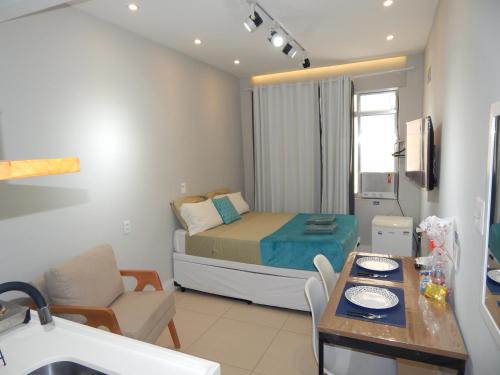 een kleine kamer met een bed en een eettafel bij Flat Atlântica na Orla de Copacabana POSTO 6 in Rio de Janeiro