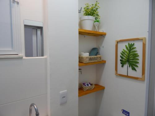 een badkamer met een wastafel en een spiegel aan een muur bij Flat Atlântica na Orla de Copacabana POSTO 6 in Rio de Janeiro