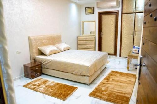 a bedroom with a bed with two rugs and a mirror at Riad dar salam in Agadir