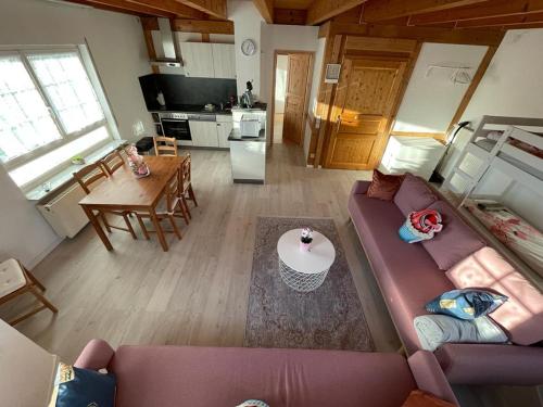 een woonkamer met een paarse bank en een keuken bij Sky Apartments in Rust