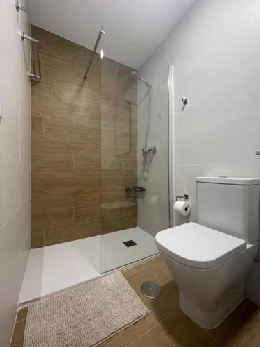a bathroom with a toilet and a glass shower at Loft Playa Villajoyosa in Villajoyosa