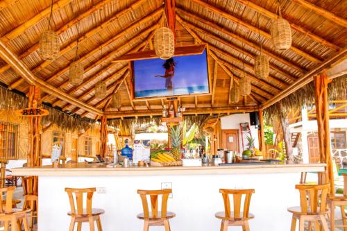 a bar with a tv on a wooden ceiling at HANGA ROA HOTEL in Montañita