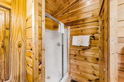 a bathroom with a shower in a wooden wall at Jolene Jolene in Pigeon Forge