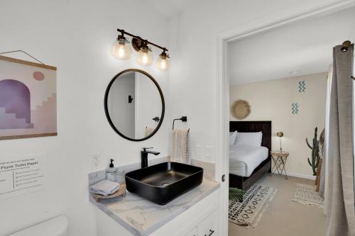 a bathroom with a black sink and a bedroom at The Quail's Nest, Dreamy Backyard,10 Mins To Jtnp in Joshua Tree