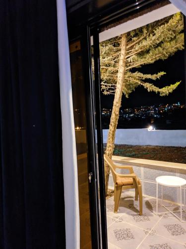 a chair and a table in front of a window at Panorama Jerash HOTEL (2) in Jerash