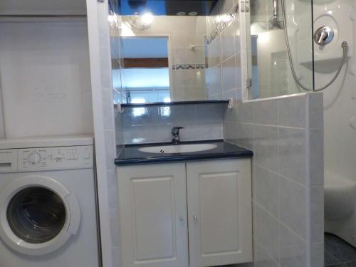 ein Badezimmer mit einem Waschbecken und einer Waschmaschine in der Unterkunft Appartement Le Lavandou, 2 pièces, 4 personnes - FR-1-308-114 in Le Lavandou