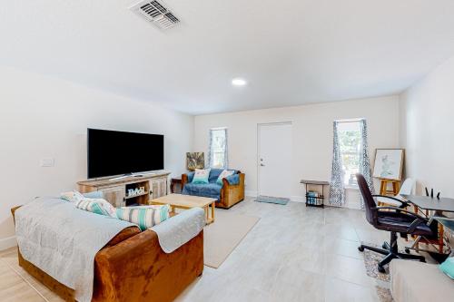 un soggiorno con divano e TV a schermo piatto di Tropical Haven Retreat a Palm Bay