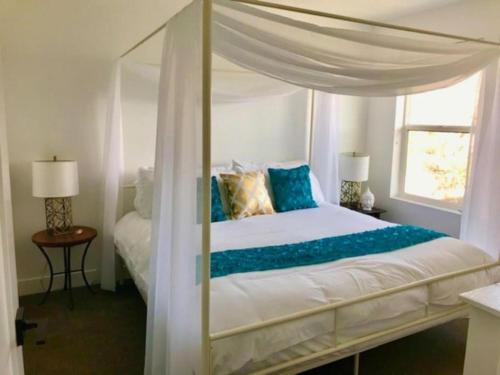 ein Schlafzimmer mit einem Himmelbett und blauen Kissen in der Unterkunft Draper Luxury Townhouse in Draper