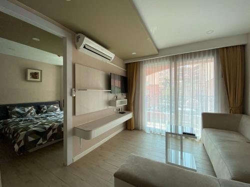 een slaapkamer met een bed en een bank in een kamer bij ΛPΛRTMENTS in Seven Seas condo in Jomtien Beach