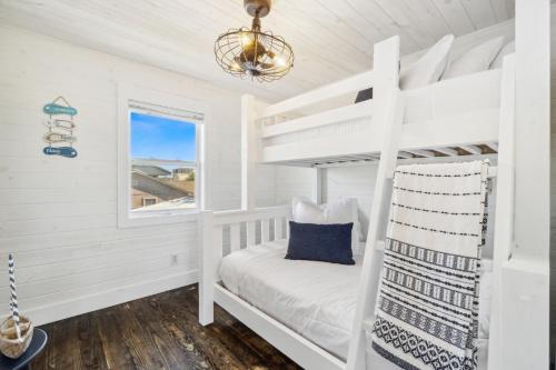 a white bunk bed in a white room with a window at Casa de la Playa - 2 Bedroom Beach House in Panama City Beach