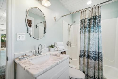 a bathroom with a sink and a toilet and a mirror at Casa de la Playa - 2 Bedroom Beach House in Panama City Beach
