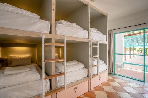 アオナンビーチにあるNomads Ao Nangの窓のある二段ベッド4組が備わる客室です。