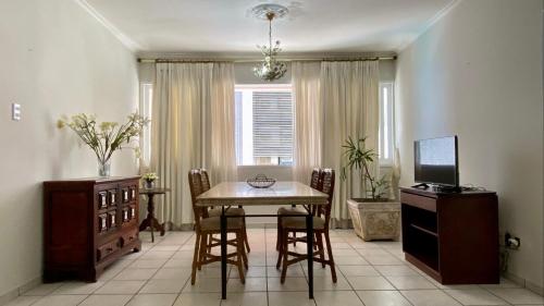 comedor con mesa, sillas y TV en Apartamento vista mar!, en Salvador