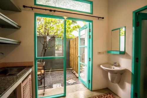 a bathroom with a green door and a sink at Nomads Ao Nang in Ao Nang Beach