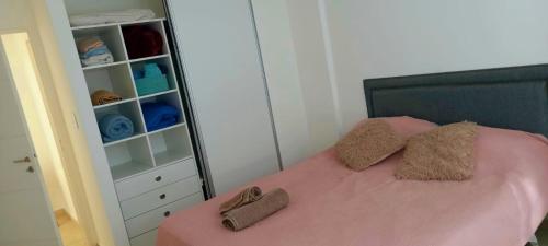 1 dormitorio con cama rosa y armario en Alojamiento JUANA I en Neuquén