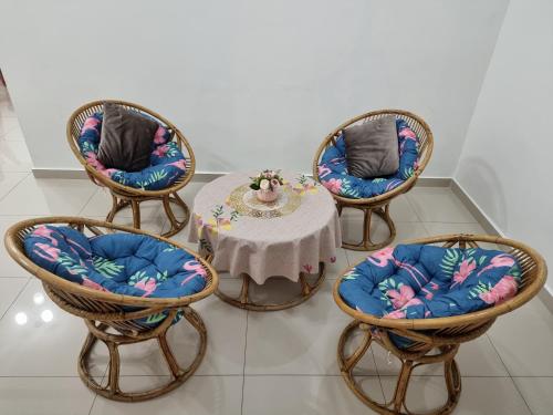 a table with three chairs and a table with at Sweethome Homestay Sandakan in Sandakan