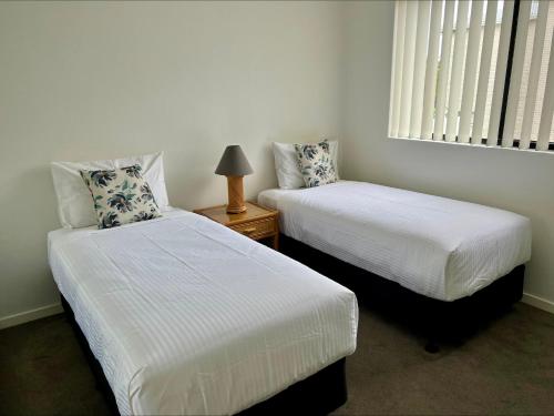 - une chambre avec 2 lits et une fenêtre dans l'établissement Hi Surf Unit 2, 92 Head Street, Forster, à Forster