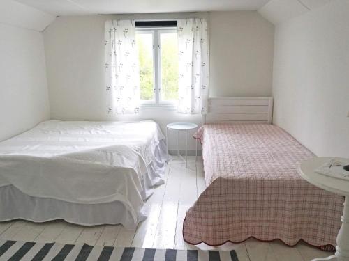a white bedroom with two beds and a window at 6 person holiday home in HALLABRO-By Traum in Hallabro
