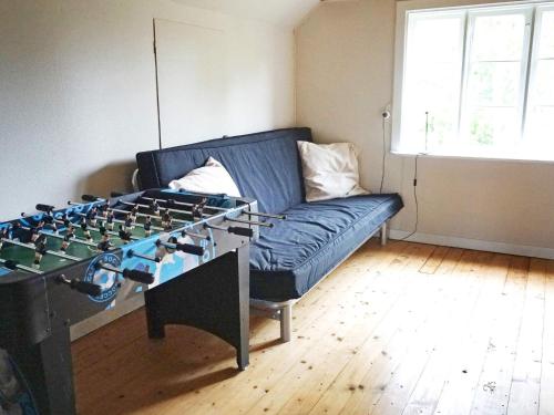 a living room with a blue couch and a foosball table at 6 person holiday home in HALLABRO-By Traum in Hallabro