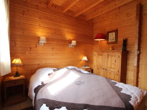 a bedroom with a bed in a log cabin at Chalet tout confort avec terrasse et poêle, animaux acceptés - FR-1-589-233 in Le Tholy