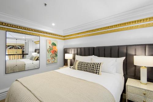 a bedroom with a large bed and a mirror at Eve Apartment - Cathedral Square in Christchurch