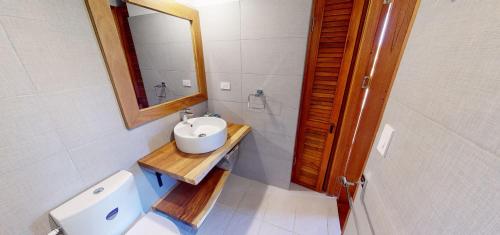 a bathroom with a sink and a mirror and a toilet at Casitas de madera in Punta Chame