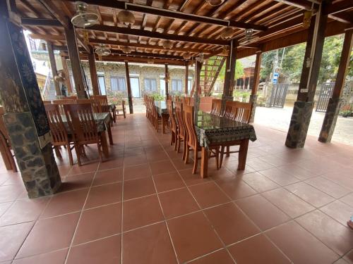 eine Terrasse mit Tischen und Stühlen auf einem Fliesenboden in der Unterkunft Duong Thim Homestay Mai Chau in Mai Châu