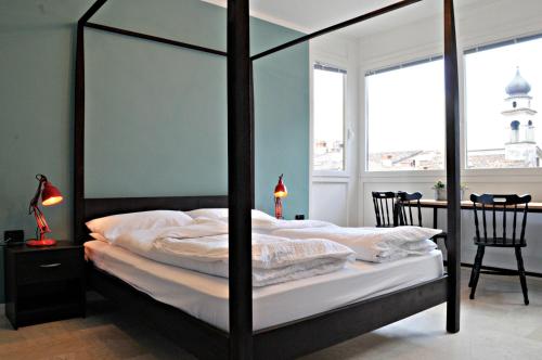 加爾達湖濱的住宿－Riva City View，一间卧室配有一张带桌椅的天蓬床