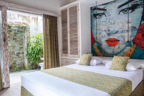 um quarto com uma cama com um mural de uma mulher em Beach Villas Lombok em Tanjung