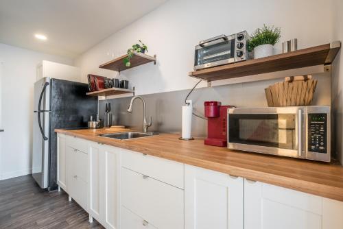 a kitchen counter with a microwave and a sink at Modern Contemporary 2 Bedroom Suite in Halifax