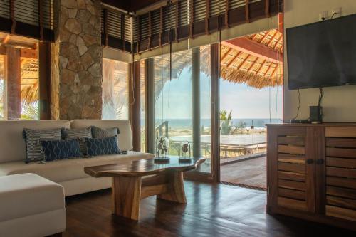 sala de estar con sofá y mesa en Casa Kundavi Beach Front Paradise en Recado