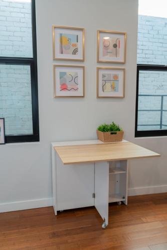 a desk in a room with pictures on the wall at Prime OTR steps to Vine St, Lux Full Bed, Workspace, fast WiFi, 50in Smart TV, Sleeps 3ppl in Cincinnati