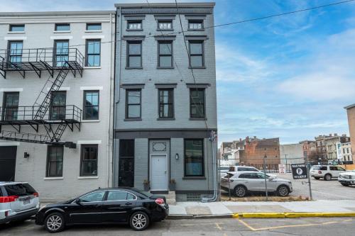 a tall building with cars parked in front of it at Prime OTR steps to Vine St, Lux Full Bed, Workspace, fast WiFi, 50in Smart TV, Sleeps 3ppl in Cincinnati