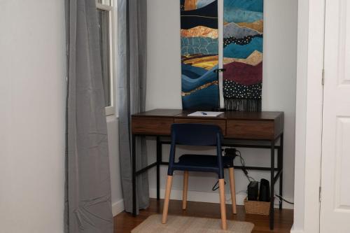 a desk in a room with a blue chair at Prime OTR steps to Vine St, Lux Full Bed, Workspace, fast WiFi, 50in Smart TV, Sleeps 3ppl in Cincinnati
