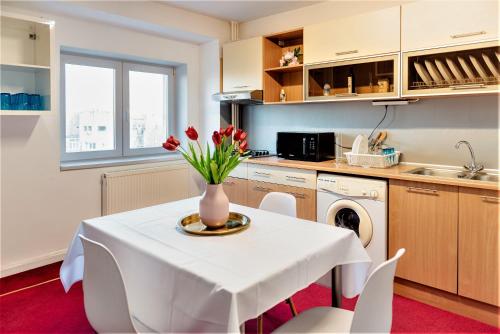 a kitchen with a table with a vase of flowers on it at Parliament Merlot Unirii Square 5 Bedrooms Luxury Apartment Old Town in Bucharest