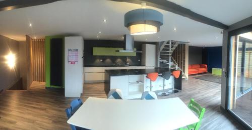a kitchen with a table and chairs and a staircase at Hôtel des Rochers in Perros-Guirec