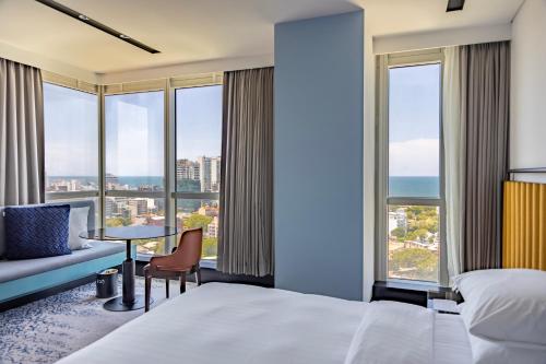 a hotel room with a bed and a table with a chair at Courtyard by Marriott Colombo in Colombo