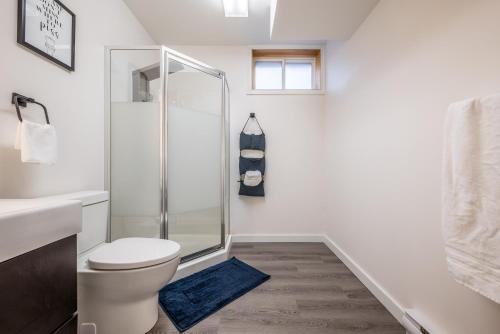 a white bathroom with a shower and a toilet at Spacious Newly Renovated 1 Bedroom Suite in Halifax