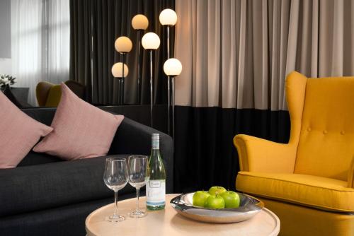 a table with two glasses and a bottle of wine at Park Regis City Centre in Sydney