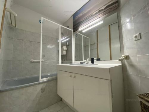 une salle de bain avec un lavabo, un miroir et une baignoire dans l'établissement Appartement T2 avec Terrasse et Garage à Cavalaire-sur-Mer - Proche Port - FR-1-100-262, à Cavalaire-sur-Mer