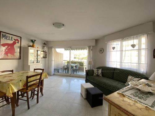 un salon avec un canapé vert et une table dans l'établissement Appartement T2 avec Terrasse et Garage à Cavalaire-sur-Mer - Proche Port - FR-1-100-262, à Cavalaire-sur-Mer