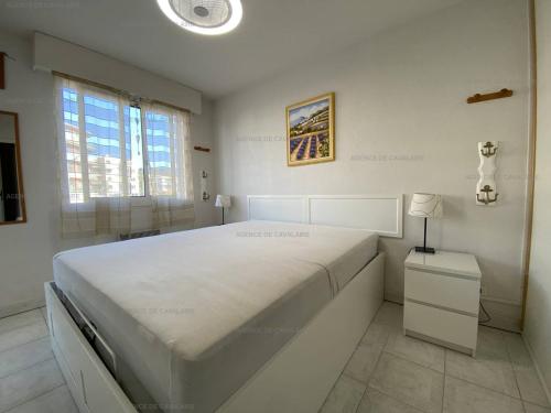 - une chambre blanche avec un grand lit blanc dans l'établissement Appartement T2 avec Terrasse et Garage à Cavalaire-sur-Mer - Proche Port - FR-1-100-262, à Cavalaire-sur-Mer
