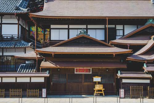 a building with a yellow stool in front of it at HOTEL MYSTAYS Matsuyama in Matsuyama