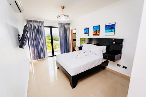a bedroom with a bed and a large window at Luxury Tropical Paradise Villa 4B Heated Pool in Camú