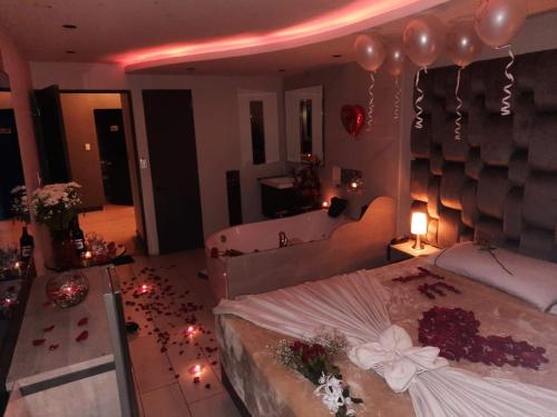a bedroom with a bed with balloons and a tub at Hotel Funza Real in Funza