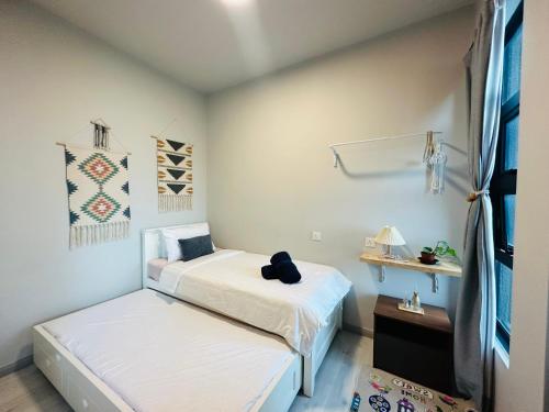 two beds in a small room with white walls at Jesselton Quay - Suite 1 by Staycation Suites KK in Kota Kinabalu
