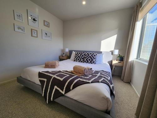 een slaapkamer met een bed en een raam bij Coastal Living in Comfort in Raglan