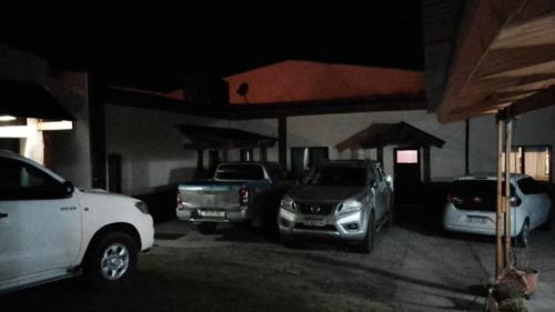 eine Gruppe von Autos, die auf einem Parkplatz geparkt sind in der Unterkunft Departamentos alvear in Esquel